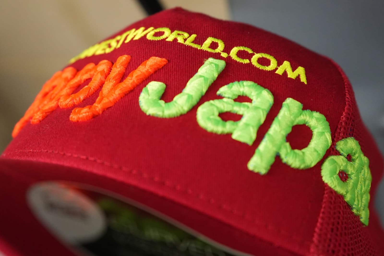 3D puff embroidered logo on a black snapback cap, showing raised foam-under-thread detail
