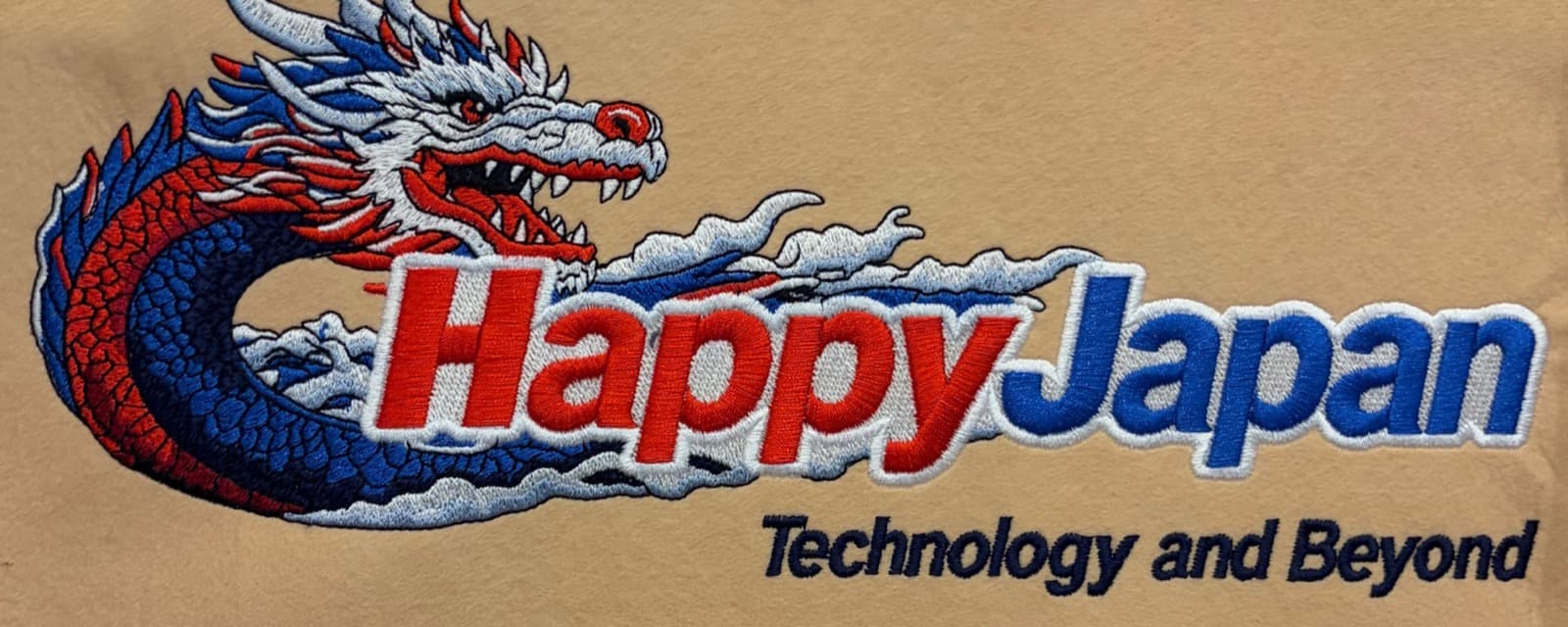 The same dragon design stitched out on fabric, dense satin and fill stitches with red lettering