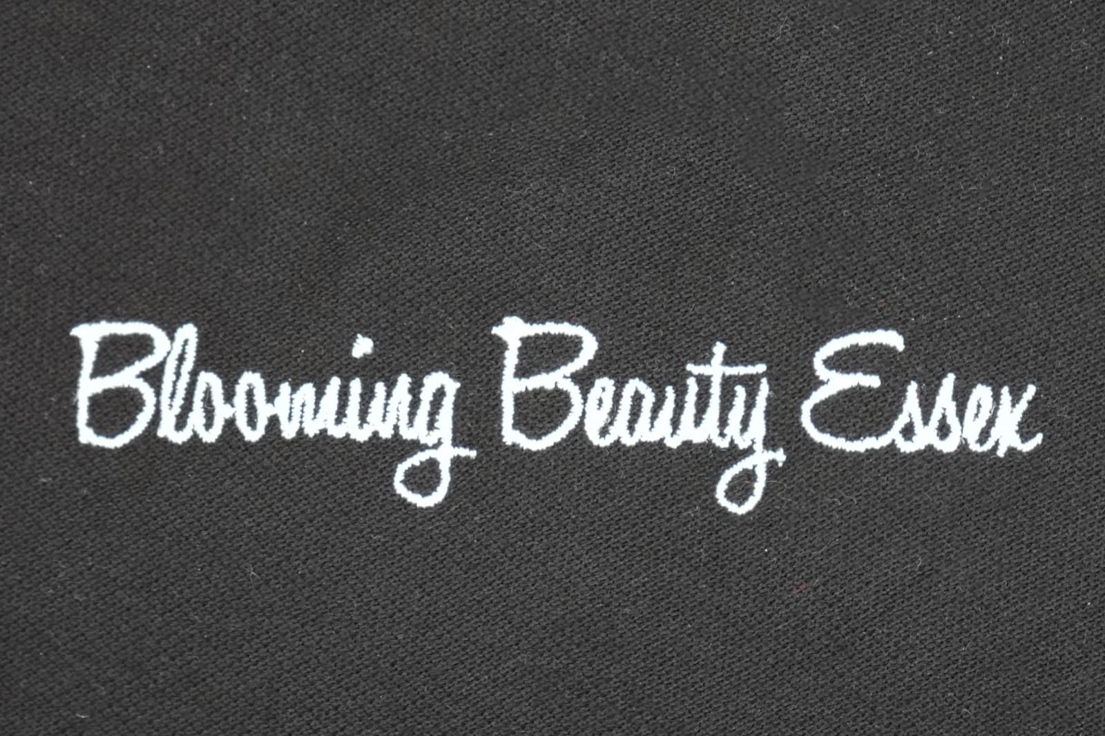 Flowing satin-stitch script lettering embroidered in gold thread
