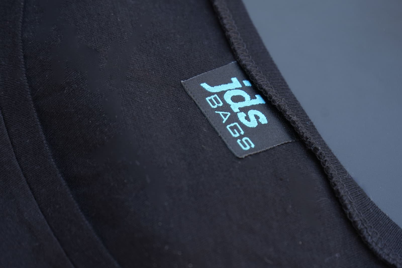 Woven garment label sewn into the neck of a cotton t-shirt